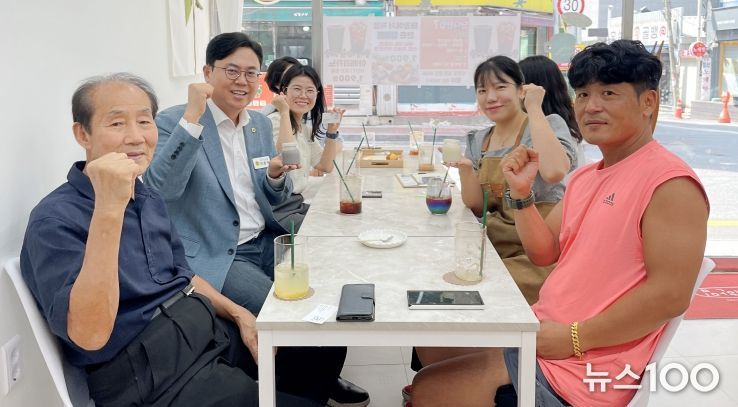 이용욱 의원(사진 왼쪽에서 가운데)과 임유진 대표(오른쪽 뒷줄) 등이 단디한입 메뉴를 들고 기념 촬영을 했다.