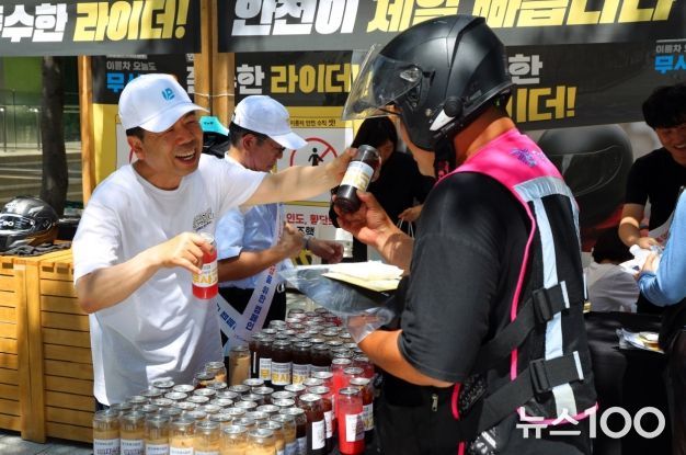 근로복지공단 박종길 이사장(왼쪽)이 지난 7월 서울 역삼역 인근에서 배달라이더들에게 시원한 음료를 나누어 주면서 고용·산재보험 거리 홍보를 진행했다.