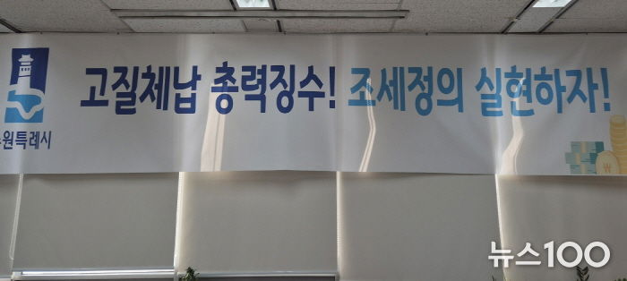 ‘고질체납 총력 징수! 조세정의 실현하자!’ 수원시 징수과 사무실에 걸려 있는 현수막.