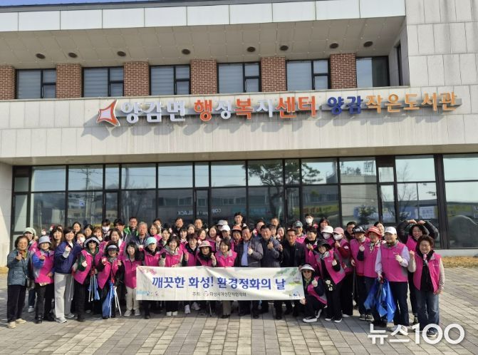 화성시여성단체협의회와 관계자들이 양감면 환경 정화 활동을 기념하고 있다