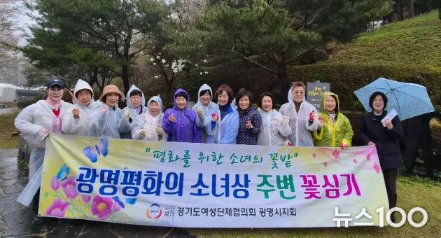 광명시 여성단체협의회가 10일 광명동굴 입구에 설치된 평화의 소녀상 주변에 봄꽃 300그루를 심고 기념사진을 촬영하고 있다.