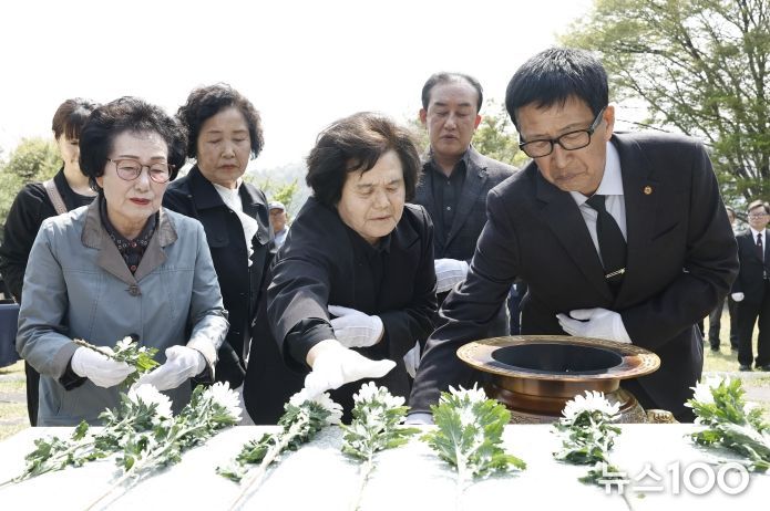 유가족과 참석자들이 제암리 순국 묘역에서 국화를 헌화하며 추모하고 있다